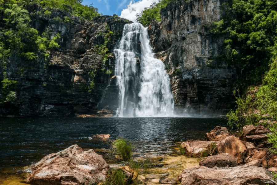 Canjica Waterfall at the Águas Lindas Complex in Cavalcante, featuring a stunning cascade surrounded by towering rock walls and a crystal-clear natural pool.