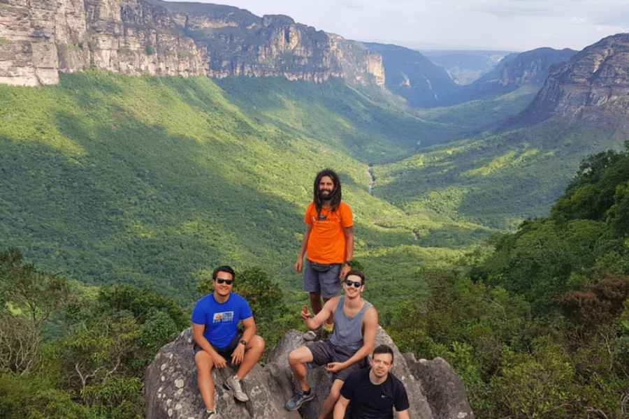 Group of four people at the viewpoint of Vale do Pati, enjoying a panoramic view of the mountains and the lush green valley of the Chapada Diamantina in Bahia.