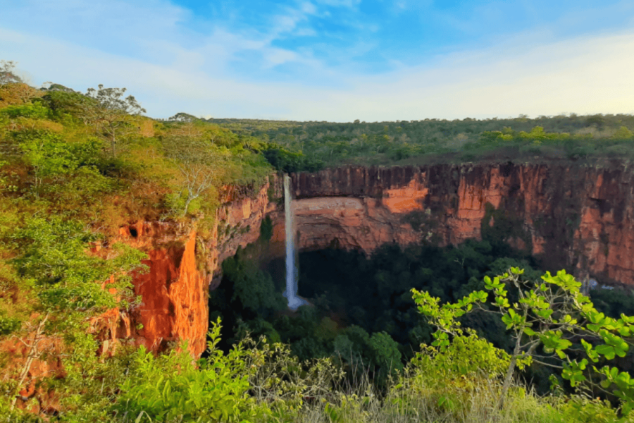 Bride's Veil Waterfall seen from the top of the canyon in Chapada dos Guimarães, surrounded by sandstone cliffs and the native cerrado vegetation.